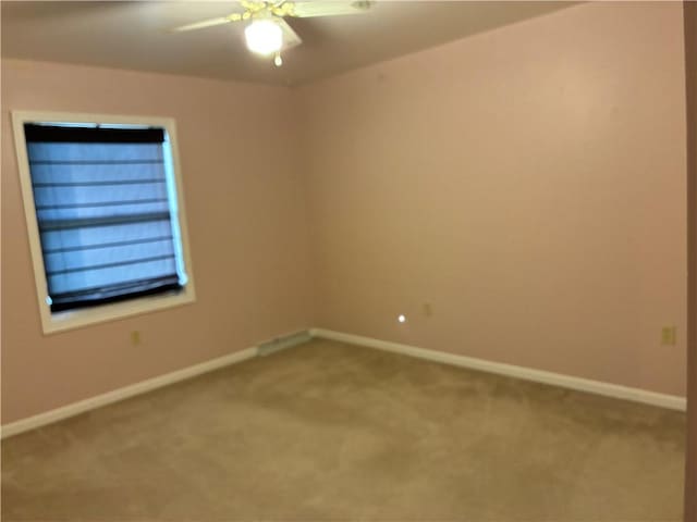 unfurnished room featuring carpet, baseboards, and a ceiling fan