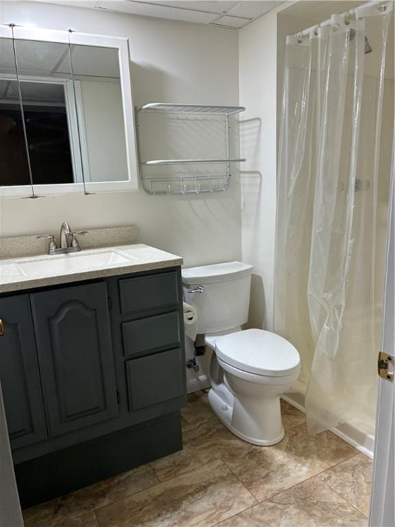 bathroom featuring toilet, vanity, a shower with shower curtain, and a paneled ceiling
