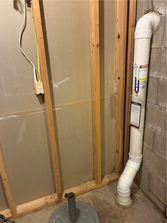bathroom with concrete flooring and concrete block wall