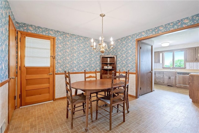 639 Scenery Dr, Elizabeth Twp/Boro, PA 15037 - dining space with brick patterned floors, wallpapered walls, a chandelier, a wainscoted wall, and baseboards