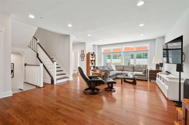 living room with wood finished floors, stairway, and recessed lighting