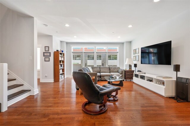 living area with wood finished floors, recessed lighting, stairs, and baseboards