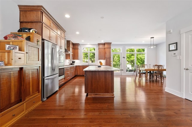 kitchen with stainless steel appliances, dark wood-style flooring, light countertops, a kitchen island, and recessed lighting