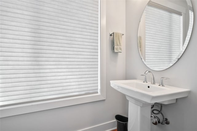 bathroom featuring baseboards and a sink