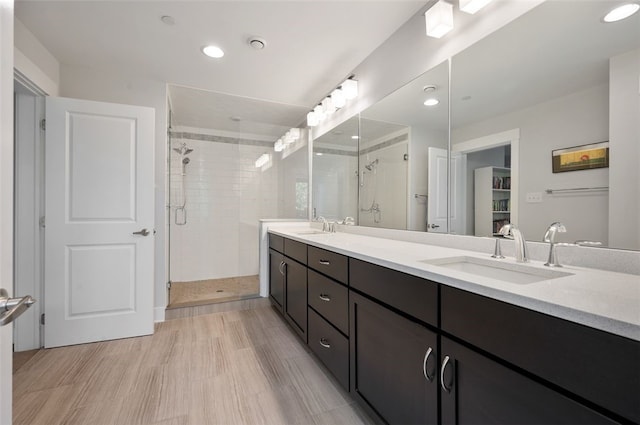 full bath with a stall shower, double vanity, and recessed lighting
