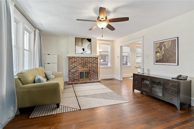 living room featuring ceiling fan, wood finished floors, a fireplace, and baseboards