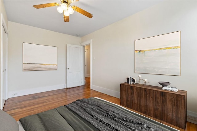 bedroom with wood finished floors, baseboards, and ceiling fan