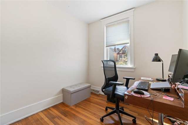 office area with baseboards and wood finished floors
