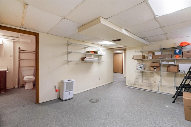 finished basement featuring a drop ceiling and baseboards