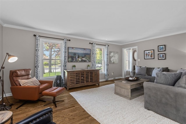 living area with ornamental molding, wood finished floors, and baseboards
