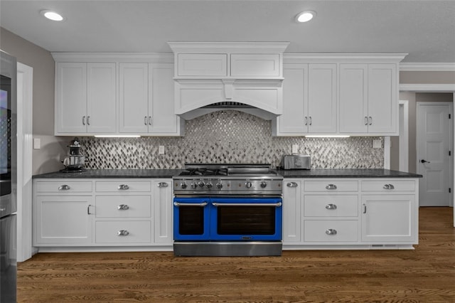 kitchen featuring range with two ovens, dark countertops, white cabinets, and recessed lighting