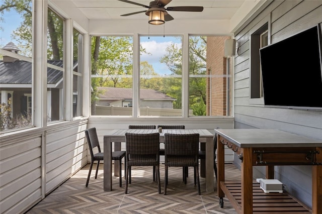 sunroom featuring ceiling fan and outdoor dining area