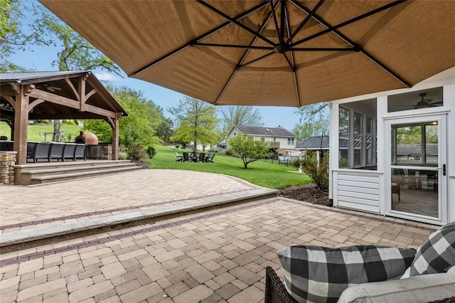 view of patio / terrace with a gazebo, a sunroom, and ceiling fan