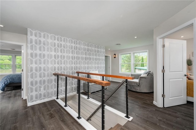 corridor with an upstairs landing, dark wood finished floors, recessed lighting, and baseboards