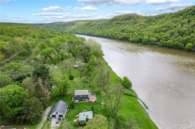 drone / aerial view of a heavily wooded area and a nearby body of water