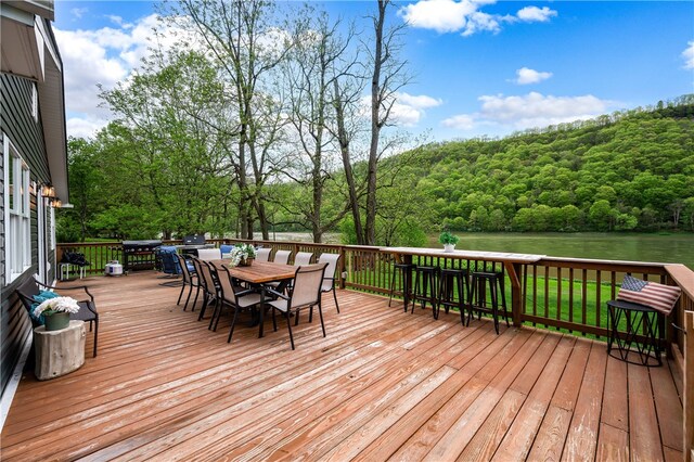145 Robinson Pl, Perry Twp Arm, PA 16041 - wooden deck featuring outdoor dining space, a view of trees, and a water view