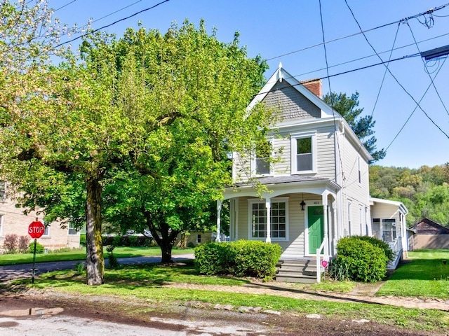 411 4th St, Darlington, PA 16115 - view of front of house with covered porch, a front yard, and a chimney