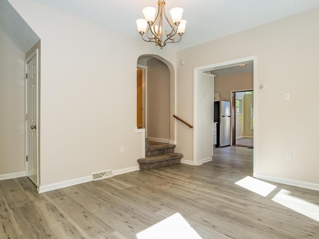 411 4th St, Darlington, PA 16115 - unfurnished dining area with arched walkways, light wood-type flooring, a chandelier, and baseboards