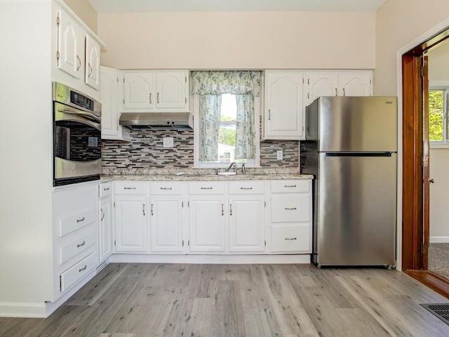411 4th St, Darlington, PA 16115 - kitchen with stainless steel appliances, under cabinet range hood, tasteful backsplash, and light wood-style floors