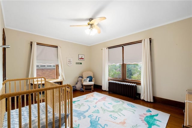 16 Morgan Ave E, Washington Boro, PA 15301 - bedroom featuring radiator, wood finished floors, ornamental molding, a nursery area, and a ceiling fan