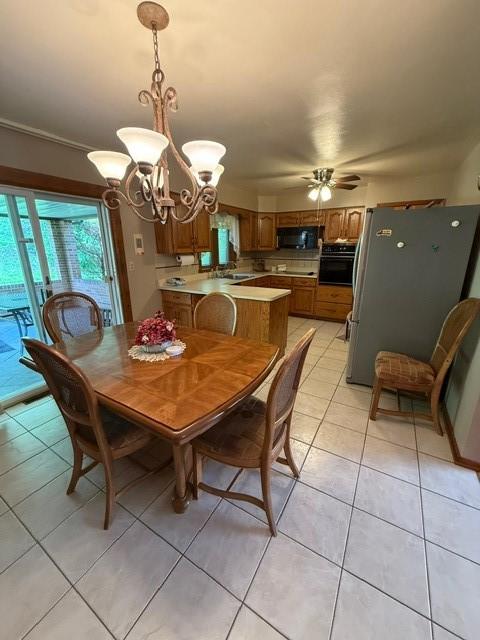 dining room with a chandelier, light tile patterned flooring, and ceiling fan