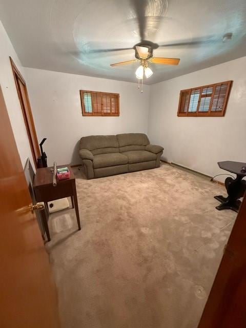 living area with carpet floors and ceiling fan