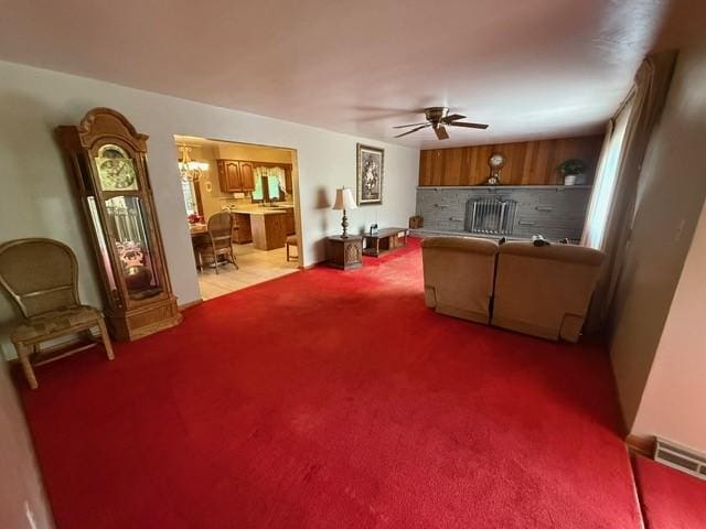 carpeted living area with ceiling fan