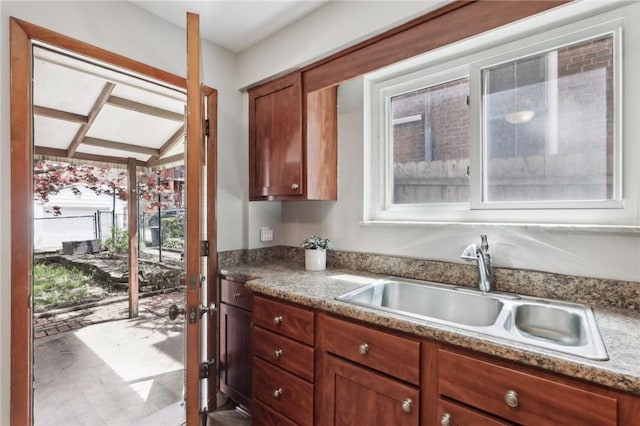 kitchen with a sink, french doors, and brown cabinetry
