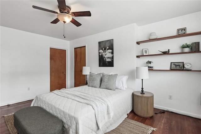 bedroom featuring baseboards, wood finished floors, and ceiling fan