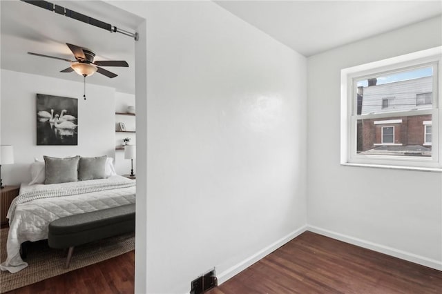 unfurnished bedroom featuring dark wood-style floors, baseboards, and a ceiling fan