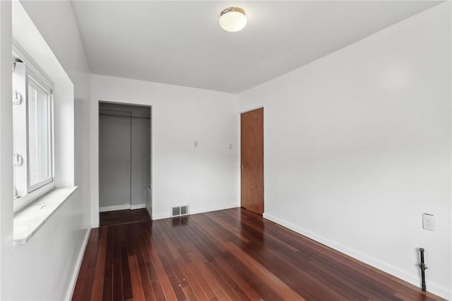 empty room with hardwood / wood-style flooring and baseboards