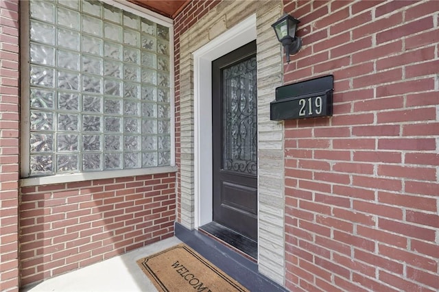 property entrance featuring brick siding
