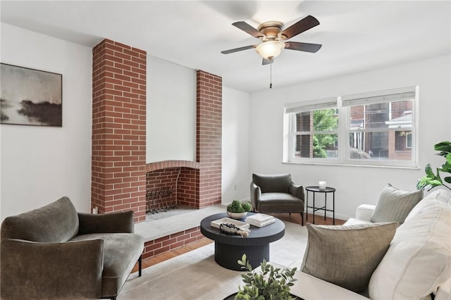 living area featuring a ceiling fan and a brick fireplace