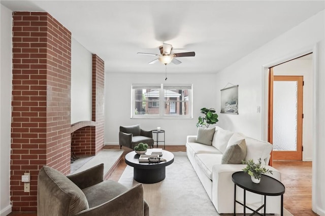 living area featuring wood finished floors, ceiling fan, and baseboards