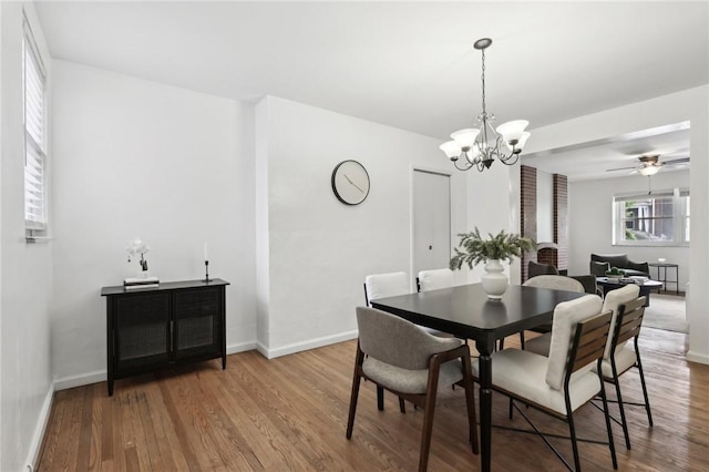 dining space featuring wood finished floors, a chandelier, and baseboards