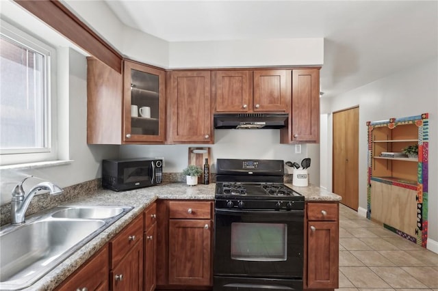 kitchen with black appliances, under cabinet range hood, a sink, light tile patterned floors, and brown cabinets
