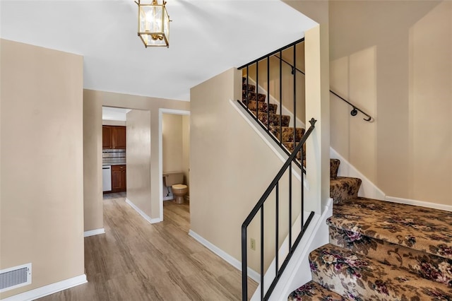 staircase featuring wood finished floors and baseboards