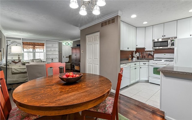 419 Avery St, East Allegheny, PA 15212 - dining space featuring a textured ceiling, ornamental molding, light wood-type flooring, a chandelier, and recessed lighting