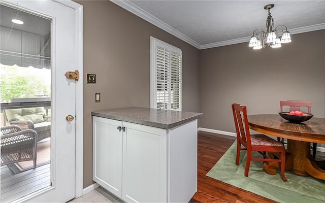 dining space with a chandelier, ornamental molding, dark wood-style floors, and baseboards