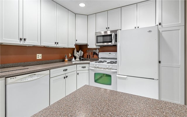 kitchen featuring white appliances, white cabinets, and recessed lighting