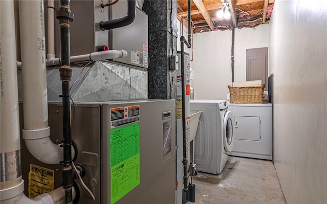 utility room with washing machine and dryer, heating unit, and electric panel