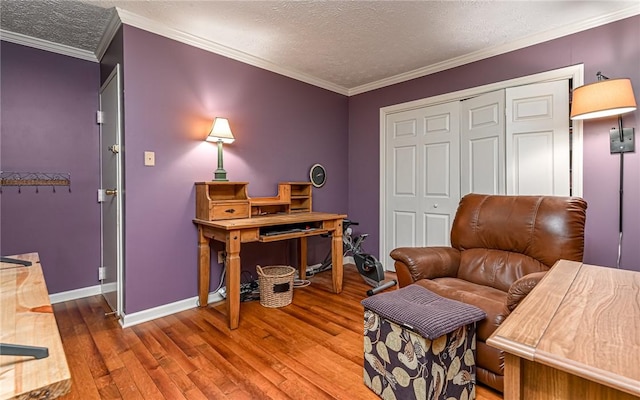 sitting room with baseboards, wood finished floors, crown molding, and a textured ceiling