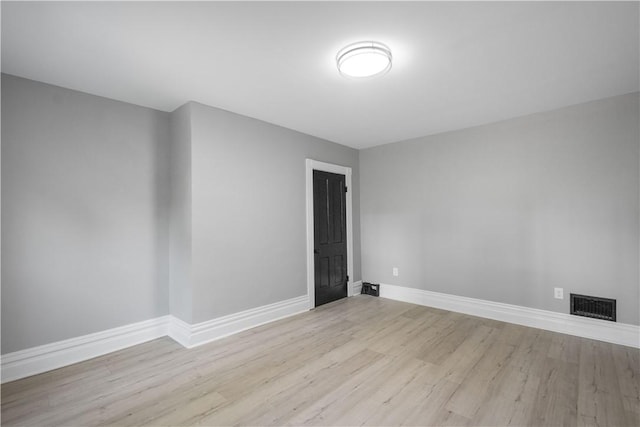 empty room with wood finished floors, baseboards, and a fireplace
