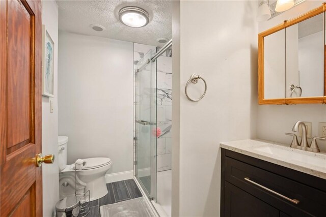 192 Wilkins Hollow Rd, Addison Twp, PA 15411 - bathroom with toilet, a shower stall, a textured ceiling, vanity, and baseboards