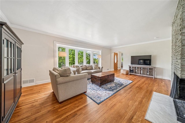 4625 Doverdell Dr, Whitehall, PA 15236 - living room featuring light wood finished floors, a fireplace, arched walkways, ornamental molding, and baseboards