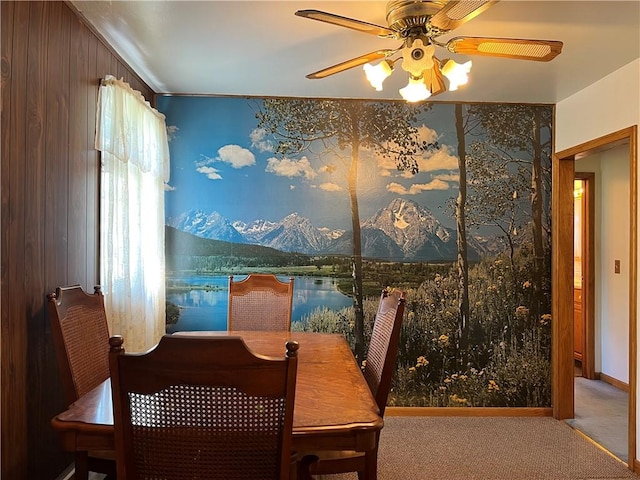 carpeted dining space with a ceiling fan