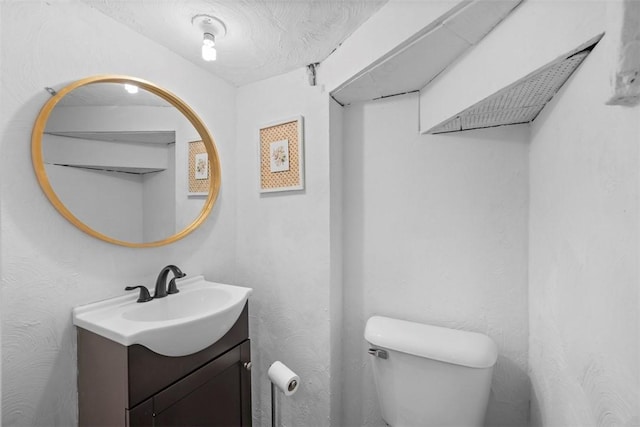 half bathroom with toilet and vanity