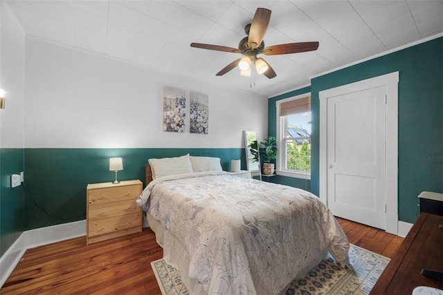 bedroom with wood finished floors, baseboards, and a ceiling fan