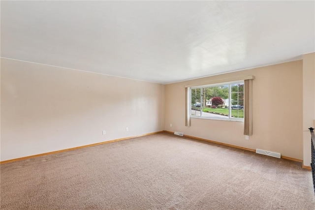 spare room featuring baseboards and light carpet
