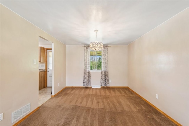 unfurnished room featuring a chandelier, carpet flooring, and baseboards